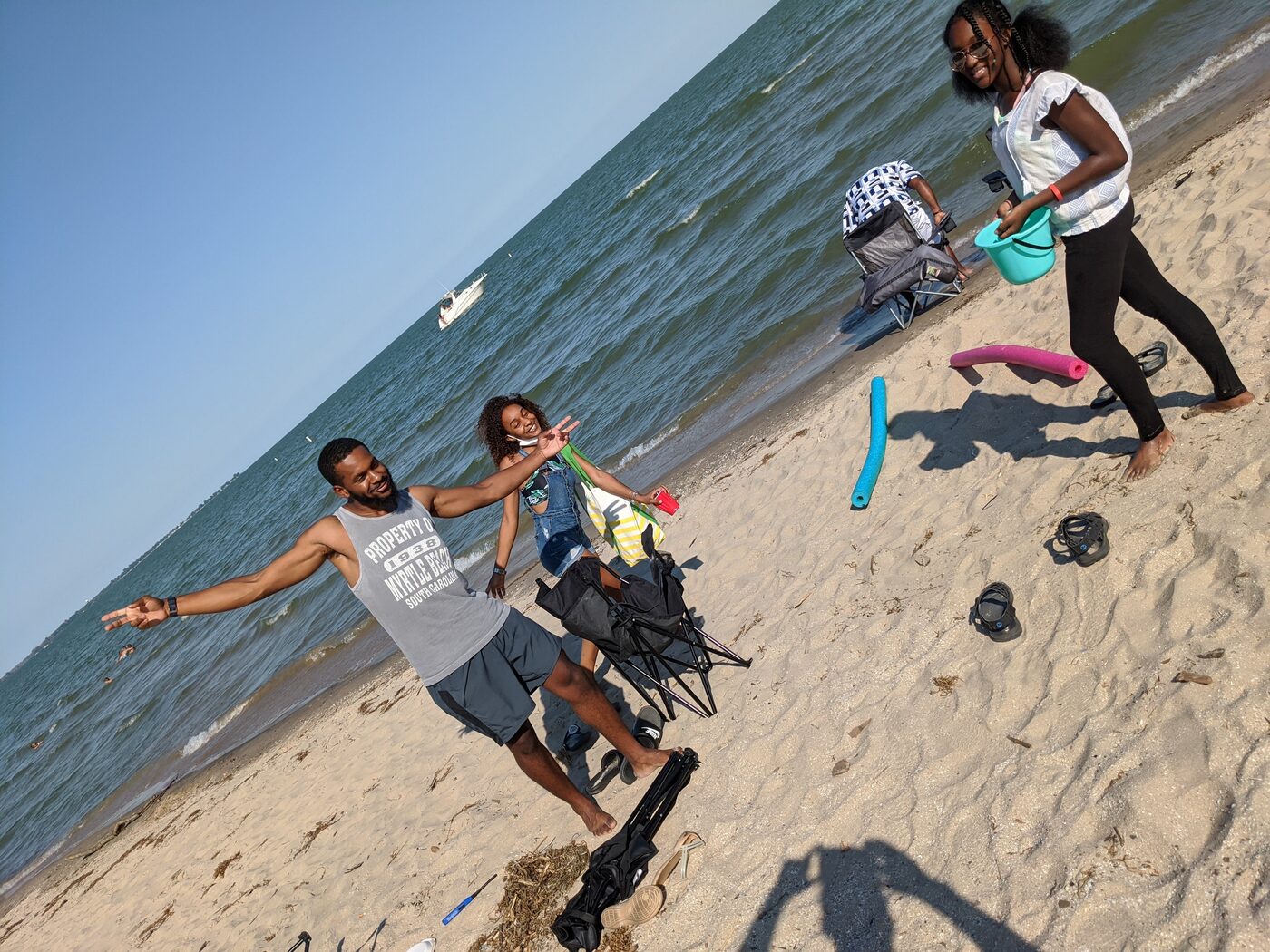 Family playing on the Lake Erie beach with floats and beach chairs